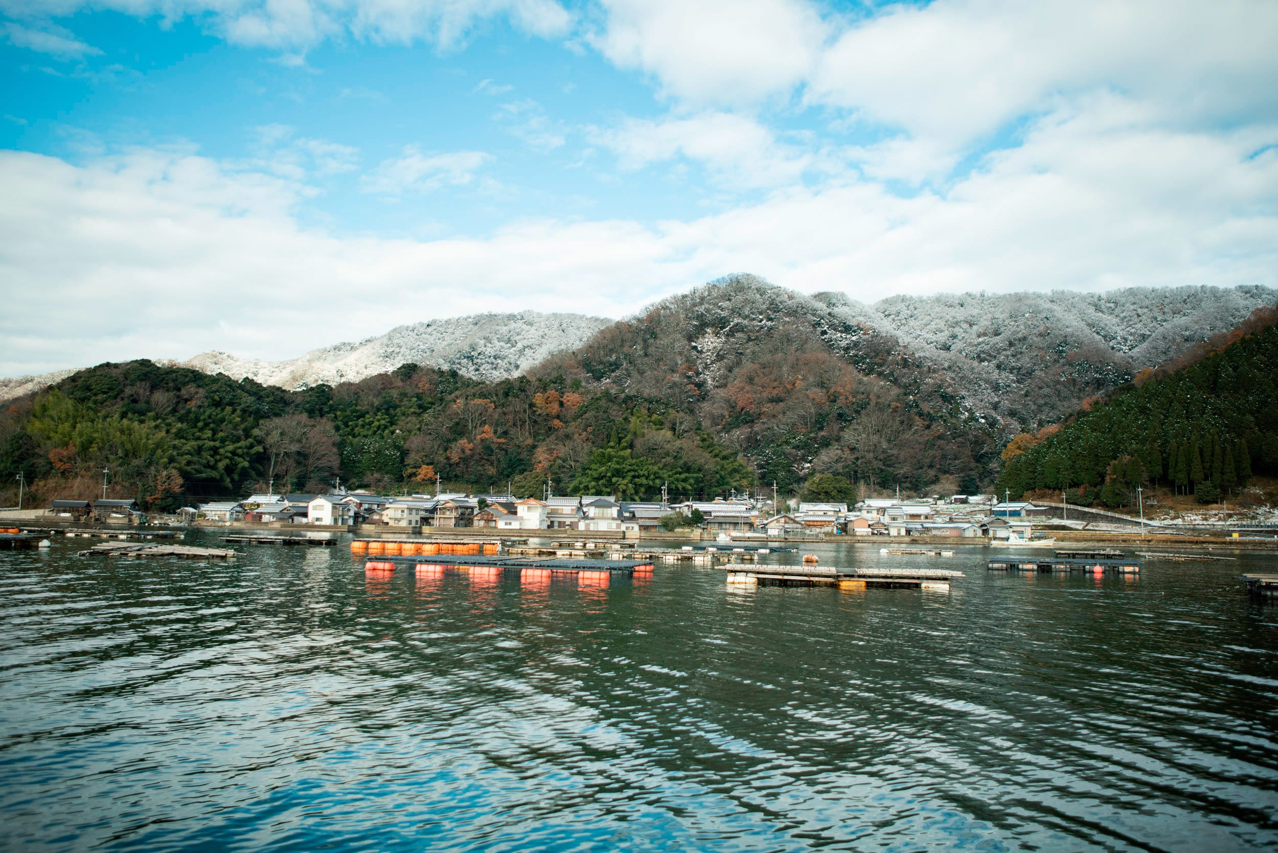 海上から見る佐波賀、手前に牡蠣筏がある。周囲の山が積雪しても、佐波賀には不思議と雪が積もらないという。